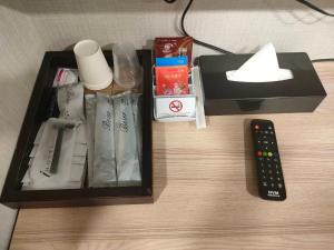 a box on a table with a remote control at Mu Chen Hotel in Kaohsiung