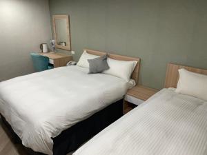 two beds in a hotel room withskirts at Mu Chen Hotel in Kaohsiung