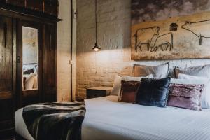 a bedroom with a large white bed with pillows at The Dairy in Castlemaine
