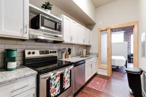 a kitchen with white cabinets and a stove top oven at Cozy Chic Retreat in the Heart of RVA in Richmond