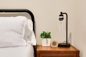 a lamp on a wooden table next to a bed at Cozy Chic Retreat in the Heart of RVA in Richmond