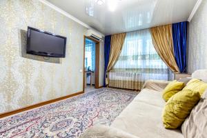 a living room with a couch and a flat screen tv at 417. Отличный вариант для туристов и командированных. Самый центр. Арбат in Almaty