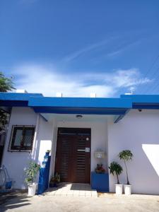 a white building with a blue roof and a door at Pension Hanadama - Vacation STAY 67585v in Arazato