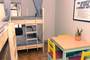 Zimmer mit Etagenbetten und einem Tisch in der Unterkunft Chillout Hostel Barrio Escalante in San José