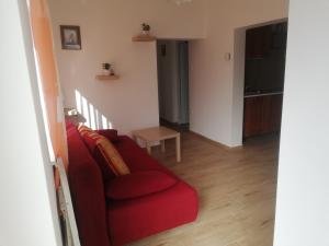 a living room with a red couch and a table at Bagolylak Vendégház Siófok in Siófok