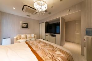 a bedroom with a large bed and a flat screen tv at HOTEL ELDIA (Adult Only) in Gyōda