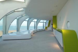 un edificio con corridoio con sedie bianche e l'oceano di i-Suite Hotel a Rimini