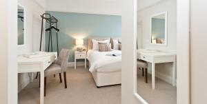 a bedroom with a bed and a desk and a mirror at The Bath Arms Hotel in Cheddar