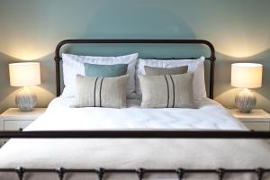 a bedroom with a bed with pillows and two lamps at The Bath Arms Hotel in Cheddar