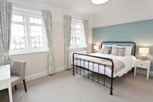 1 dormitorio con 1 cama y 2 ventanas en The Bath Arms Hotel, en Cheddar