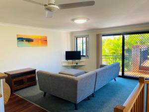 a living room with a couch and a tv at Sharon Lee 1 in Rainbow Beach