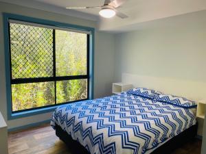 a bedroom with a bed and a large window at Sharon Lee 1 in Rainbow Beach