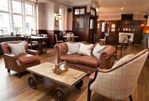 a living room with couches and chairs and a table at The Bath Arms Hotel in Cheddar