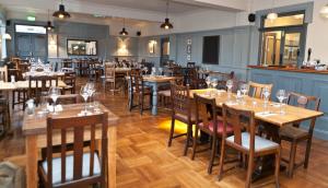 a dining room with wooden tables and chairs at The Bath Arms Hotel in Cheddar