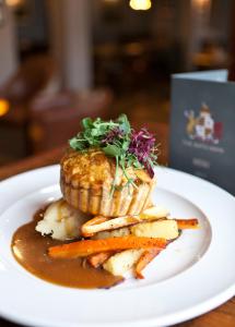 a plate with a piece of food with carrots and gravy at The Bath Arms Hotel in Cheddar