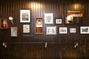 a wall with framed photographs on a wooden wall at The Bath Arms Hotel in Cheddar