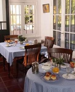 a dining room with a table with food on it at Posada De La Plaza in San Antonio de Areco