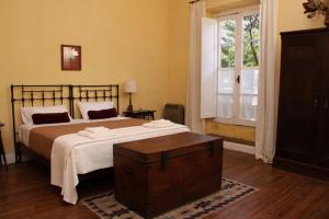 Un dormitorio con una cama grande y una ventana en Posada De La Plaza en San Antonio de Areco