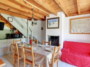 ein Esszimmer mit einem Tisch und einem roten Sofa in der Unterkunft Appartement Viey, 3 pièces, 7 personnes - FR-1-402-120 in Viey