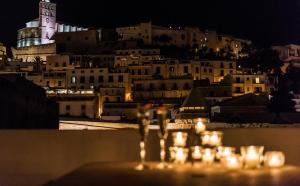 uma vista da cidade à noite com velas em Apartamentos Mariano em Cidade de Ibiza