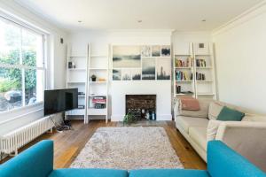 a living room with a couch and a fireplace at Fantastic 3 Bedroom Flat West Hampstead in London