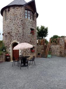 une terrasse avec une table et des chaises devant un bâtiment dans l'établissement La Tour de Ver Gite atypique Possibilité table d'hôtes sur réservation, à Ver