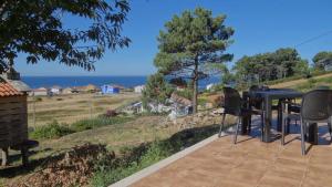 a table and chairs on a patio with a view of the ocean at Casa Florinda Casa con terraza in Lariño