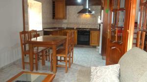 a kitchen with a wooden table and chairs and a stove at Casa Florinda Casa con terraza in Lariño