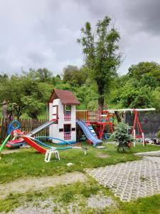 a playground with a small house and slides at Casa Tican in Bran