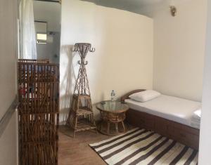 Green Mandala Inn في كاتماندو: غرفة نوم بسرير وطاولة زجاجية