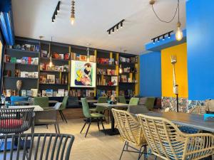 a library with tables and chairs and bookshelves at Solei Apartments in Primorsko