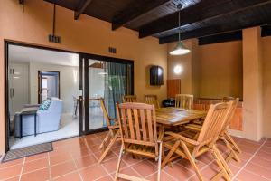 uma sala de jantar com uma mesa de madeira e cadeiras em San Lameer Villa 3212 - 4 Bedroom Superior - 8 pax - San Lameer Rental Agency em Southbroom