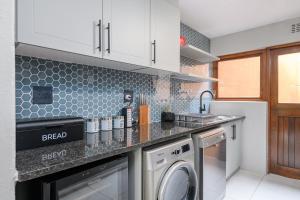 uma cozinha com uma máquina de lavar roupa e um lavatório em San Lameer Villa 3212 - 4 Bedroom Superior - 8 pax - San Lameer Rental Agency em Southbroom