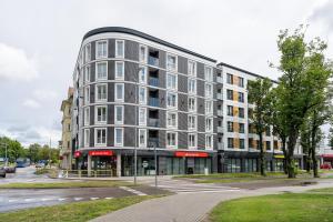 duży szary budynek na ulicy z światłem ulicznym w obiekcie Apartament DIAMOND w Kołobrzegu