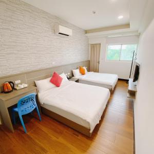pokój hotelowy z 2 łóżkami i telewizorem w obiekcie Full House w mieście Jinning