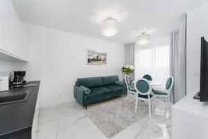 salon z zieloną kanapą i stołem w obiekcie Apartament DIAMOND w Kołobrzegu