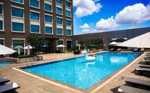 une piscine dans un hôtel avec une piscine gonflable en face d'un bâtiment dans l'établissement Hotel Nikko Saigon, à Hô-Chi-Minh-Ville