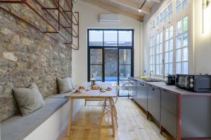 a kitchen with a table and a stone wall at Incomparable Plaka's Luxury Apt Private Pool in Athens