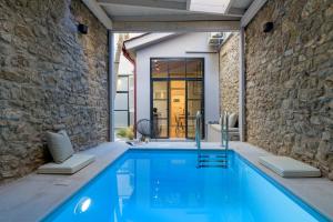 a pool in a house with a stone wall at Incomparable Plaka's Luxury Apt Private Pool in Athens