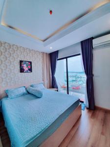 um quarto com uma cama e uma grande janela em Căn Hộ TMS 28 Nguyễn Huệ - Xuan Phuong House em Quy Nhon