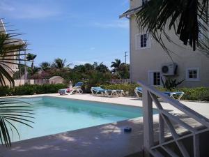 a swimming pool with two chairs and a house at Dreamy Haven in Runaway Bay