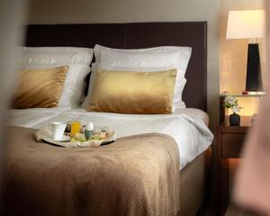 ストックホルムにあるエリート エデン パーク ホテルの食べ物のトレイが載ったベッド