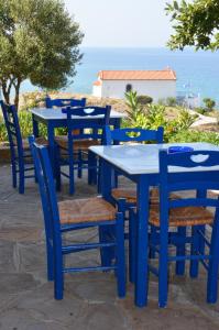 a blue table and chairs with the ocean in the background at Sunset Hotel in Agios Ioannis Kaspaka +37 photos