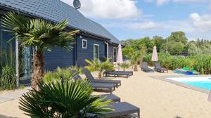 a resort with a pool and chairs and a building at Rodzinne Rusinowo II in Rusinowo