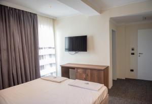 a hotel room with a bed and a television at Hotel Roma in Struga