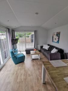 a living room with a couch and a table at Aloha-Olmenduin in Serooskerke