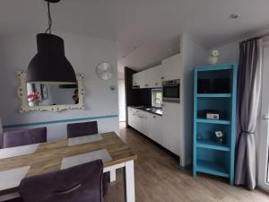 a kitchen and dining room with a table and chairs at Aloha-Olmenduin in Serooskerke