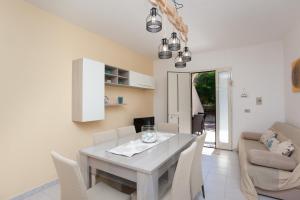 a kitchen and dining room with a table and chairs at Appartamento Brezza Marina in Budoni