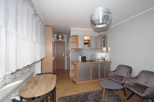 a kitchen with a table and chairs in a room at Nadmorskie Pokoje i Apartamenty in Krynica Morska