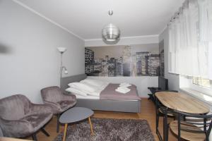 クリニツァ・モルスカにあるNadmorskie Pokoje i Apartamentyのベッドルーム1室(ベッド1台、テーブル、椅子付)